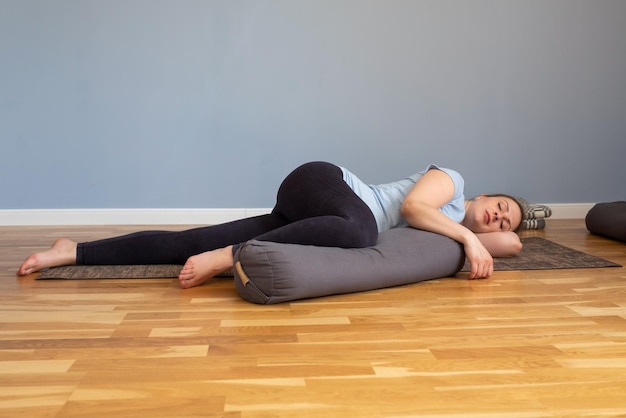 Pregnant woman lying in Shavasana resting after practice meditating breathing