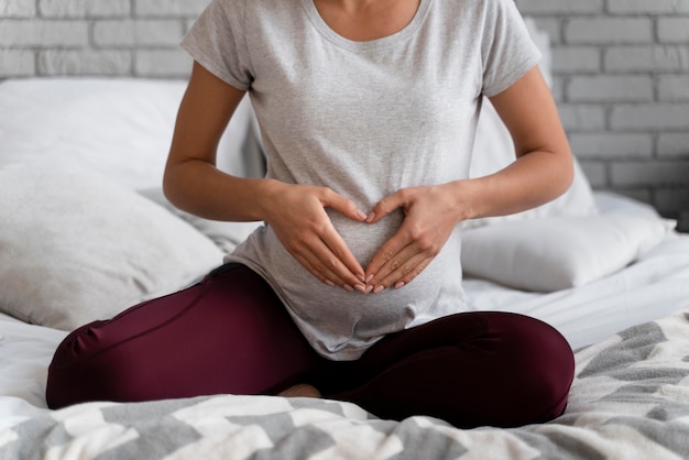 Photo pregnant woman making a heart on her belly