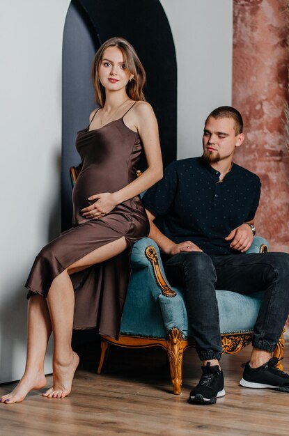 a pregnant woman and a man are sitting in a chair