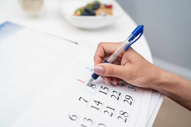 The pregnant woman marks the date of birth on the calendar