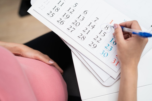 The pregnant woman marks the date of birth on the calendar