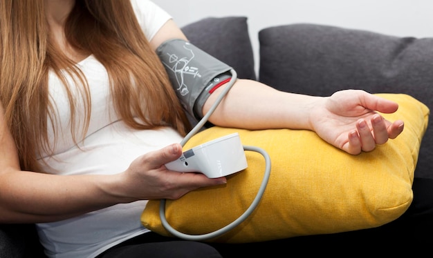 The pregnant woman measures blood pressure at home