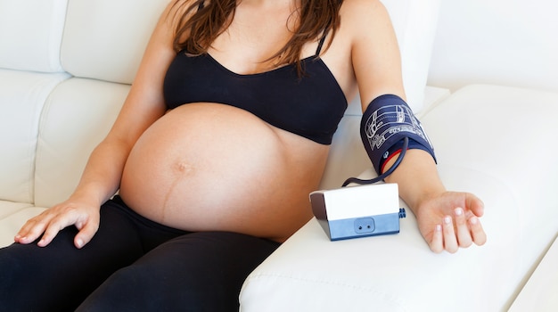 Pregnant woman measures the blood pressure