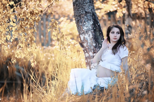 Pregnant woman in nature for a walk in the autumn