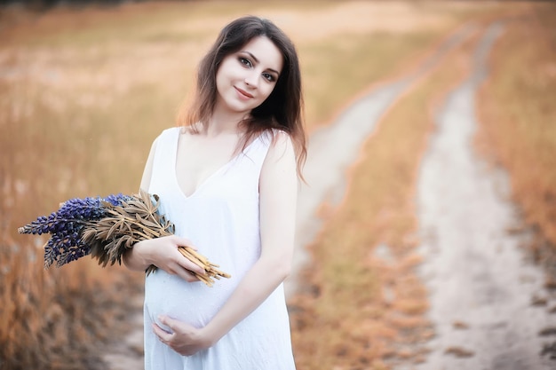 Pregnant woman in nature for a walk in the autumn