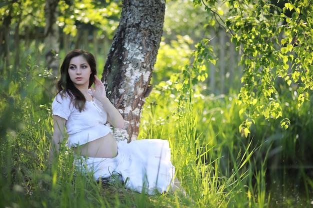 Pregnant woman in nature for a walk summer