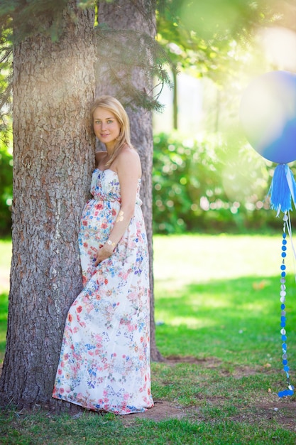 Pregnant woman in outdoor park, warm weather