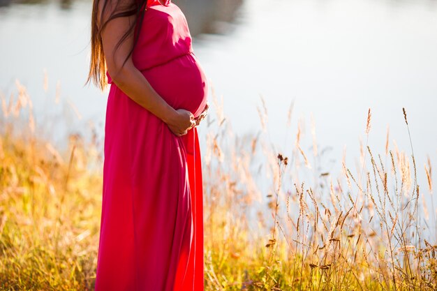 Pregnant woman in outdoor park, warm weather