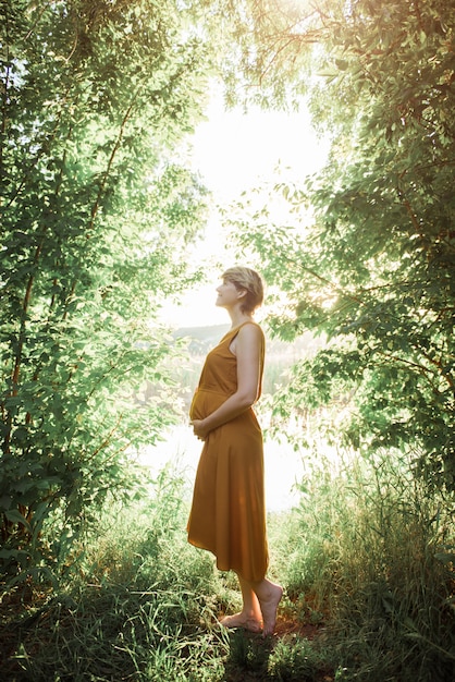 Donna incinta in tempo caldo del parco all'aperto