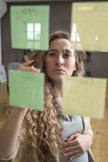 Foto donna incinta che pianifica il lavoro in ufficio