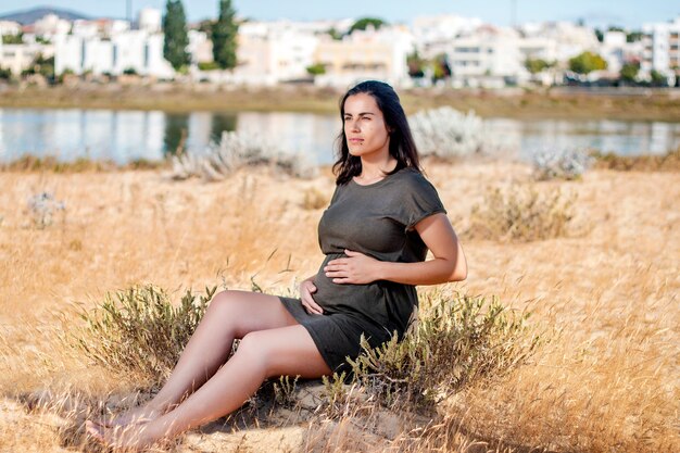 Pregnant woman poses on the dunes