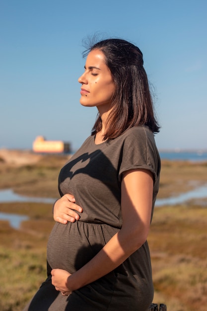 Pregnant woman poses on the marshlands.