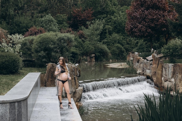 pregnant woman in a raincoat in the park