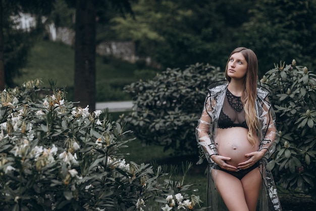 pregnant woman in a raincoat in the park