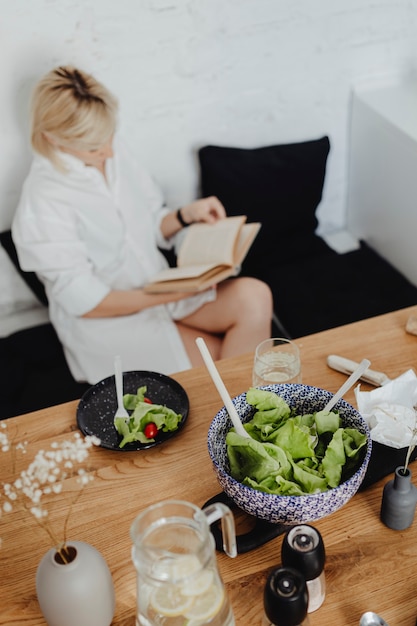 写真 食べながら本を読んでいる妊婦