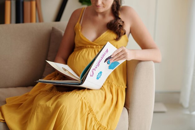 Pregnant woman reading book for pregnant women