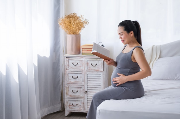 Donna incinta che legge un libro per il relax.