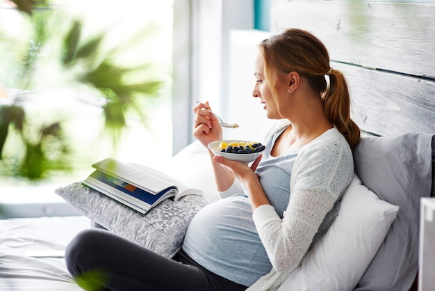 Pregnant woman relaxing at bedroom