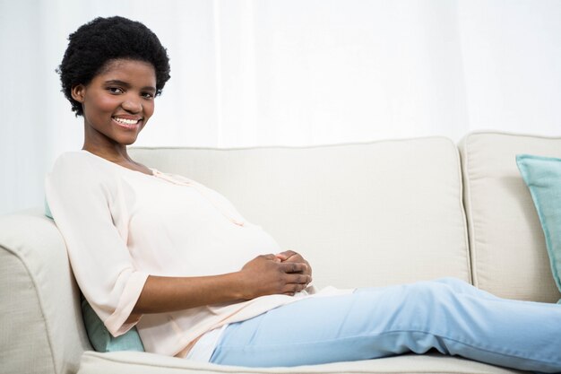 Pregnant woman relaxing on couch at home 