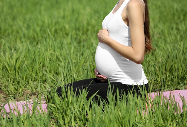 Pregnant woman relaxing in field