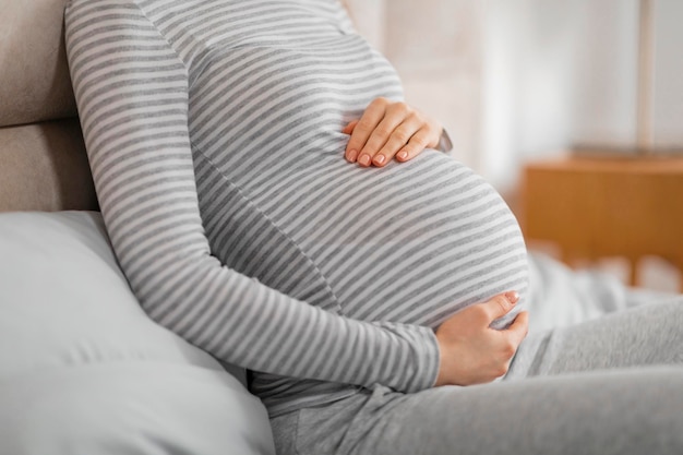 Pregnant woman resting hands on baby bump