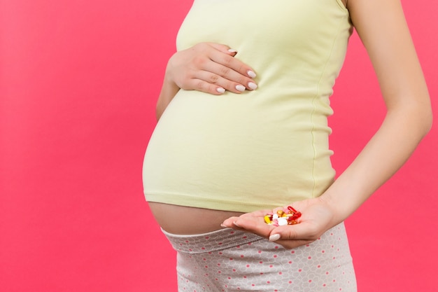 Pregnant woman showing lots of pills