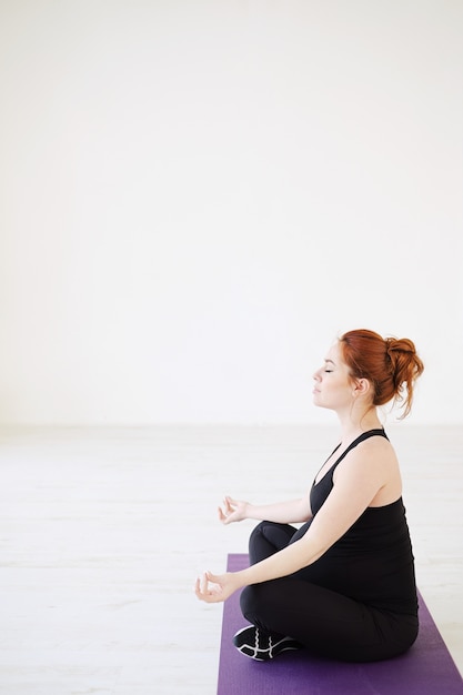 Pregnant woman sitting in lotus pose relaxing