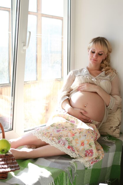 Pregnant woman sitting near the window