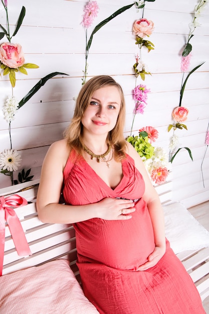 Photo pregnant woman sitting in the red dress