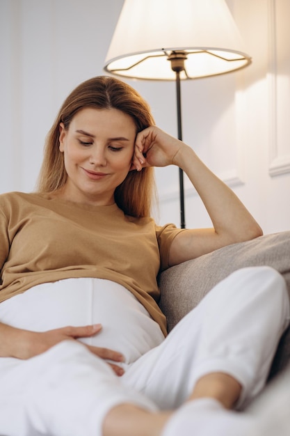 自宅のソファに座っている妊婦