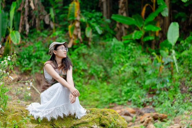 Pregnant woman sitting at the waterfall