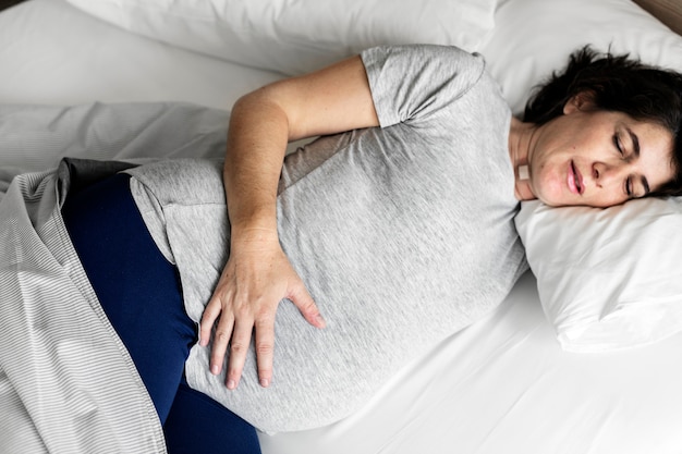 Donna incinta che dorme sul letto