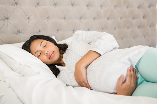 Pregnant woman sleeping in bedroom