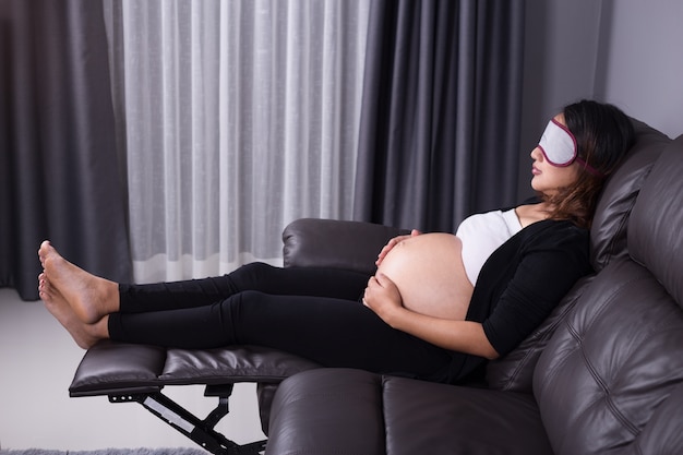 Pregnant woman sleeping on sofa