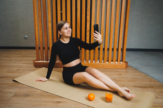 A pregnant woman in sportswear is sitting on a sports mat Pregnant woman doing sports healthy lifestyle of pregnant women