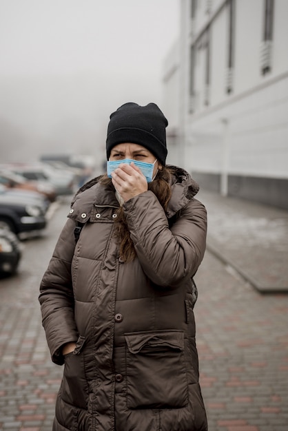 A pregnant woman stands on the street of a European city during an epidemic of coronavirus.