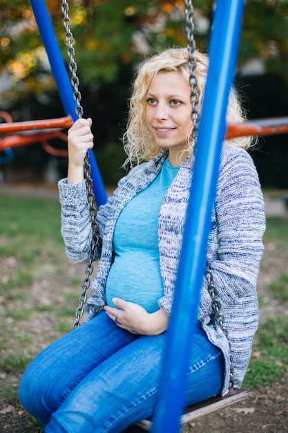 Pregnant woman on the swing