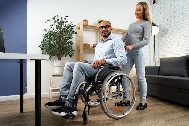 Pregnant woman takes care of her disabled husband in wheelchair