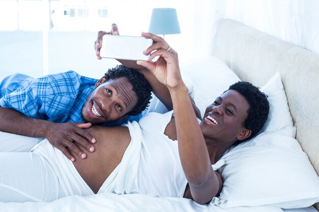 Pregnant woman taking selfie while relaxing 