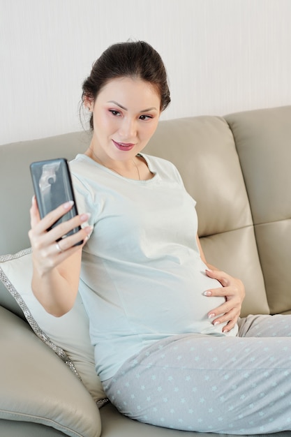 Pregnant woman taking selfie