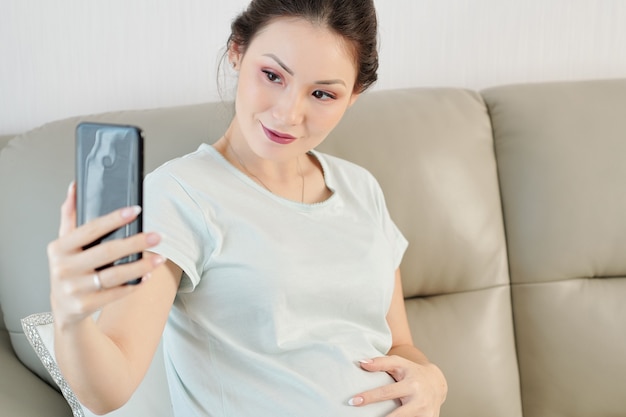 Pregnant woman taking selfie