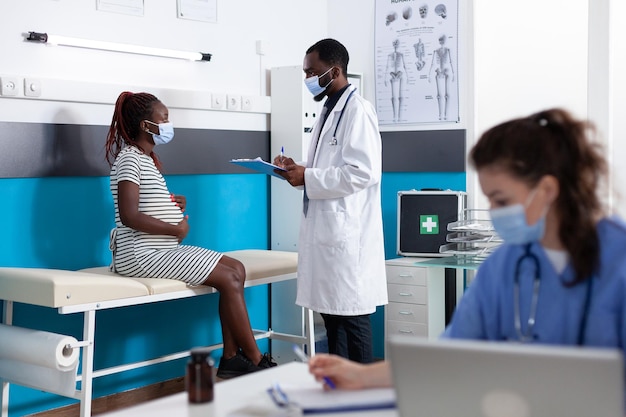 Pregnant woman talking to doctor at checkup appointment