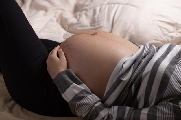 Pregnant woman touching her belly in the bed Pregnancy motherhood and expectation