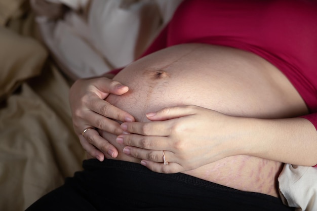 Фото Беременная женщина трогает живот в постели беременность материнство и ожидание