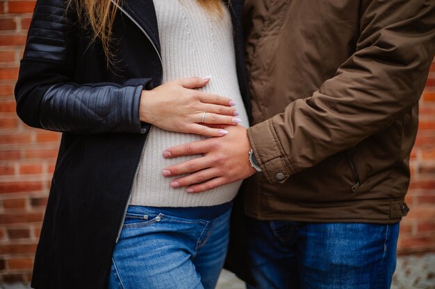 pregnant woman touching her belly with hands.