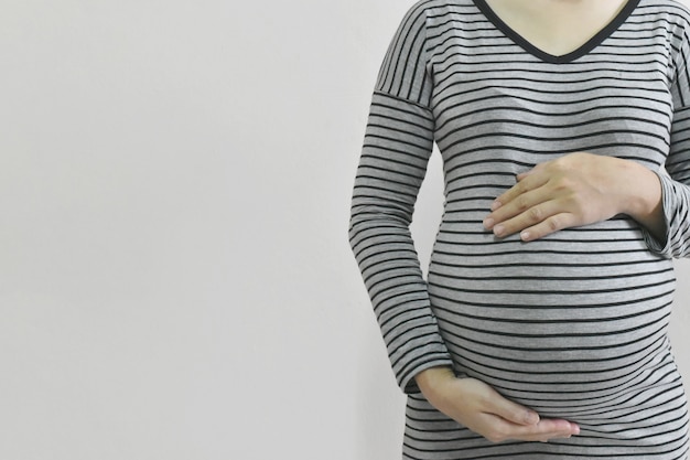 Pregnant woman touching her belly.