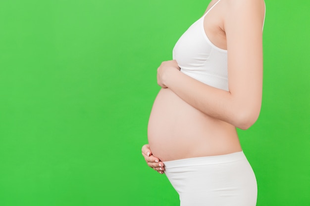 беременная женщина, касаясь ее живот
