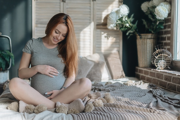 Pregnant woman touching and looking to her belly