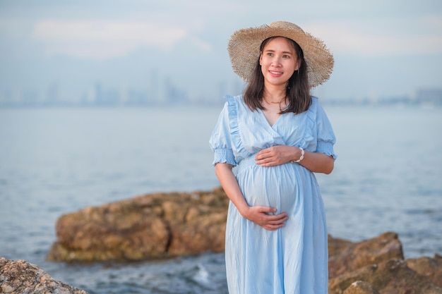 Pregnant woman traveling to the sea happy