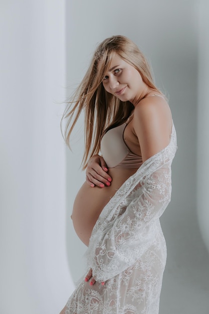 Беременная женщина в нижнем белье. Студийный снимок